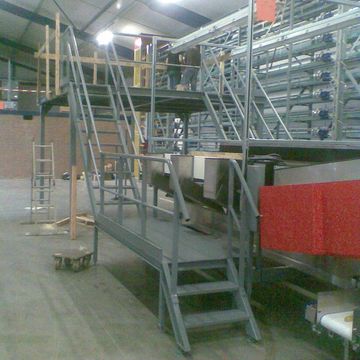 Vaste trappen met looppaden om veilig over of tussen de productielijnen te komen.