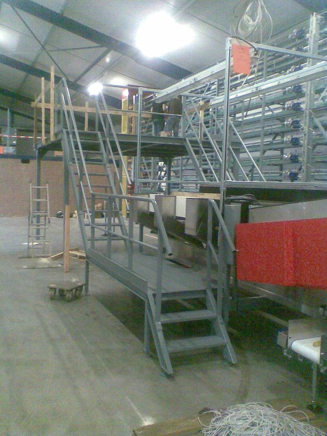 Vaste trappen met looppaden om veilig over of tussen de productielijnen te komen.